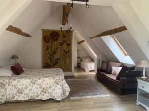 La Bihourderie في Azay-sur-Indre: غرفة نوم بسرير واريكة في العلية