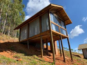 a small house on wooden posts in the dirt at Montanha Home in Monte Verde