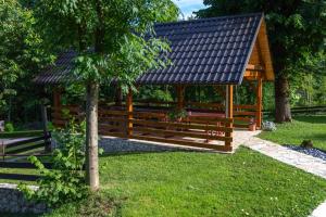 ein hölzerner Pavillon in einem Park mit einem Baum in der Unterkunft Apartment Sara in Rakovica
