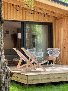 a deck with chairs and a couch on a house at Camping Swory in Swornegacie 