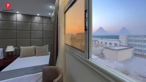 a room with a bed and a window with a view at Pyramids Residence view inn in Cairo