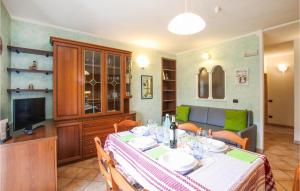 a dining room with a table and a television at Amazing Apartment In Mezzana With Wifi in Mezzana