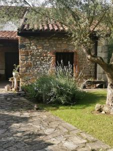a stone house with a tree in front of it at Casa Rural Erre Q Erre in Oreña