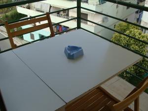 une boîte bleue assise sur une table blanche avec un banc dans l'établissement Seashore Serenity Apartment, à Golem
