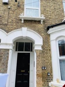 a brick house with a black door and a window at 2nd floor shared flat near Bedford train station in Bedford