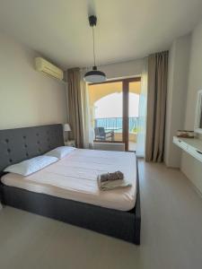 een slaapkamer met een groot bed en een balkon bij Cabacum Beach Residence AP.20 in Varna