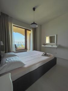 een slaapkamer met een groot bed en een groot raam bij Cabacum Beach Residence AP.20 in Varna