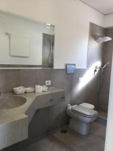a bathroom with a toilet and a sink and a mirror at spettacolare suite Tragara Capri in Capri