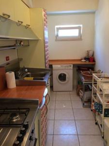 a kitchen with a sink and a washing machine at spettacolare suite Tragara Capri in Capri