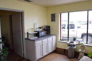 cocina con encimera, microondas y ventana en Delux Inn, en Odessa