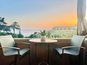 una mesa con sillas y una mesa con una planta en el balcón en Royal Villa - Ocean View - Heated Pools - SEASCAPE'S BEST 1 BEDROOM - 3 BEDS - End Unit, en Aptos