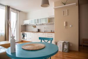 プラハにあるApartment Terezaの青いテーブル付きのキッチンが備わるアパートメントです。