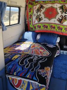 una cama en la parte trasera de una furgoneta con una manta en Casa movil, en Santa Gertrudis