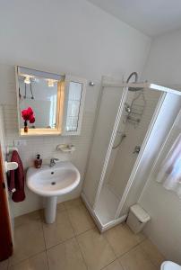 a white bathroom with a sink and a shower at Le Trottole Apartment in Palermo