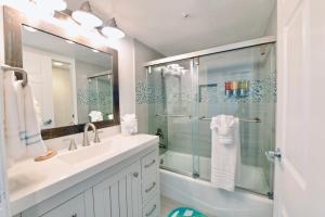 baño con lavabo y ducha con puerta de cristal en Royal Villa - Ocean View - Heated Pools - SEASCAPE'S BEST 1 BEDROOM - 3 BEDS - End Unit, en Aptos