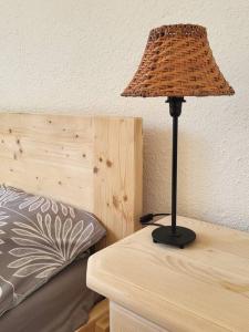 a lamp sitting on top of a table next to a bed at Na Dębowej- Apartament/dom 2 pokoje-prywatny las in Szczytna