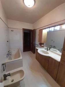 uma casa de banho com um lavatório, 2 lavatórios e uma banheira em Villa Pina - Relaxing view & BBQ em Sulzano