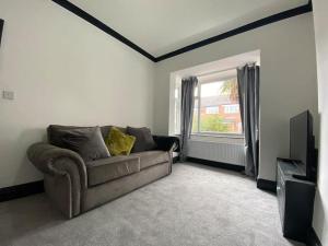 a living room with a couch and a window at 3 bed house Hyde near Manchester in Hyde