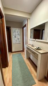 y baño con lavabo, espejo y alfombra. en APART SANTANDER ZONA UNIVERSIDAD, en Santander