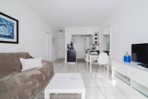 a white living room with a couch and a table at BEACH VIBES in Miami Beach