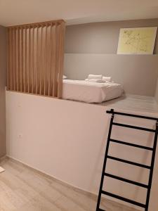 Zimmer mit einem Bett an einer Wand mit einer Leiter in der Unterkunft Old town studios in Kavala