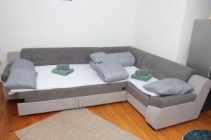 a bed with four pillows on it in a room at Ema Apartman in Livno