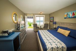 a bedroom with a bed and a sink and a mirror at Strawberry Hill Seaside Inn in Rockport