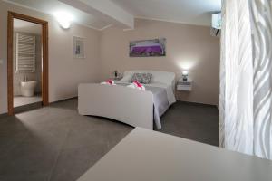 - une chambre avec un lit blanc et un canapé blanc dans l'établissement Villa Falcone, à Alvignano