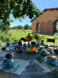 una mesa con platos y tazones de comida. en Tenuta Di Paternostro, en Vetralla