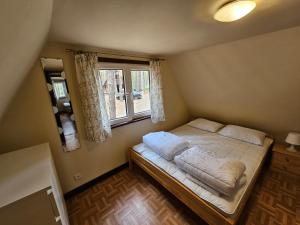 ein kleines Schlafzimmer mit einem Bett und einem Fenster in der Unterkunft Jak Tu Sielsko in Osiek