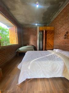 a bedroom with a white bed in a brick wall at Casa - El Arrecife in Engabao