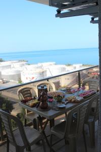 a table with food on a balcony with a view of the ocean at FENDE DOLG SUITE APARTMENTS in Cimenli
