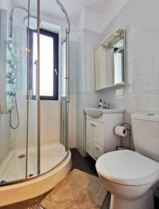 een badkamer met een douche, een toilet en een wastafel bij GGMamaia in Mamaia