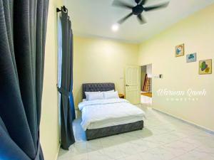 1 dormitorio con 1 cama y ventilador de techo en Warisan Qaseh Homestay en Tanah Merah