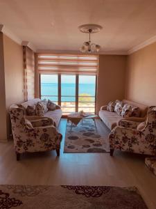 a living room with two couches and a large window at FENDE DOLG SUITE APARTMENTS in Cimenli