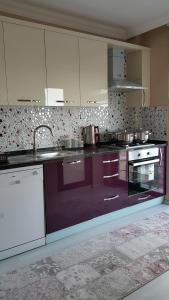 a kitchen with purple counters and white cabinets at FENDE DOLG SUITE APARTMENTS in Cimenli