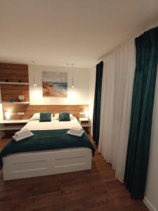 1 dormitorio con 1 cama con sábanas verdes y blancas en Didova kuća, en Brodarica
