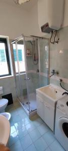 La salle de bains est pourvue d'une douche et d'un lavabo. dans l'établissement Ferienwohnung mit Meerblick im Juwel Le Castella, à Le Castella