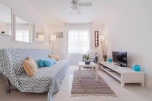 ein Wohnzimmer mit einem Sofa und einem TV in der Unterkunft OCEAN & SAND ONLY 1 MINUTE WALK! in Miami Beach