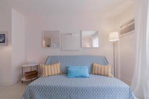 ein Schlafzimmer mit einem blauen Bett mit zwei Kissen in der Unterkunft OCEAN & SAND ONLY 1 MINUTE WALK! in Miami Beach