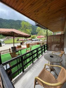 a patio with a table and chairs on a deck at ÇAVUŞ APART in Uzungol
