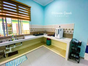 una cocina con 2 lavabos y una cafetera en una encimera en Warisan Qaseh Homestay en Tanah Merah