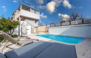 a swimming pool with chairs and a house at Didova kuća in Brodarica
