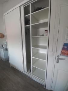 a white cabinet with glass doors in a room at Lauraym 1 in Baie-Mahault