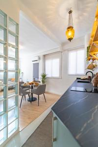 a kitchen and living room with a table and chairs at Livemálaga San Agustín Suite & Terrace in Málaga