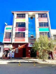 un edificio alto con ventanas coloridas en una calle en Hostal Graciela, en Oruro