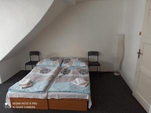 a bedroom with two twin beds and two chairs at Penzion u Jakuba in Svoboda nad Úpou