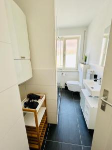 uma casa de banho branca com um lavatório e um WC em 3Room-Central-Modern- The Seashell by SA-Grandeur em Friedrichshafen