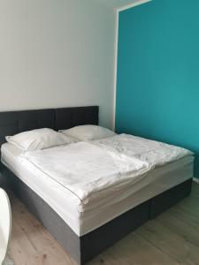 uma cama com uma moldura preta e lençóis brancos em Nr 3 Ferienwohnung am Teutoburger Wald 