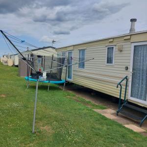an rv parked in a yard next to a house at warden springs caravan park MS16 Thornhill road, Eastchurch,ME124HF in Sheerness